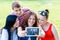 Group of four happy smilng young people friends taking picture of themselves with tablet