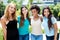 Group of four international laughing young adult women