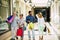 Group of four people attended the mall going shopping together with shopping bags on their hands - seniors and adults at the