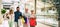 Group of four people going shopping together holding shopping bags with presents or gifts for christmas - buying clothes and more