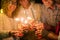 Group of four people having fun and enjoying holding glasses of champagne and sparklers celebrating the happy new year together