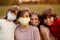 Group of four school age girlfriends wearing protective masks await end of pandemic lockdown and back to normality