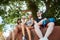 Group of four tourists sitting under tree near temple in thailand