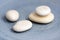 Group of four white pebbles on blue background, simplicity stone cairn with zenstones