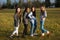 Group of four young girl firends standing and posing outside