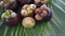 Group of fresh exotic tropical thai fruit mangosteens garcinia mangostana with digital cryptocurrency bitcoin rotating