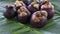 Group of fresh exotic tropical thai fruit mangosteens garcinia mangostana rotating on banana leaf