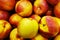 Group of fresh raw loose bulk yellow orange red peaches nectarines in a pile