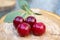 Group of fresh ripened fruits on wooden pad, red sour cherries