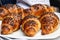 Group of freshly baked croissants decorated with chocolate chips lies on a white plate