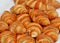 Group of freshly baked croissants in a pastry shop shelf