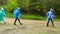 Group of friends with backpacks in raincoat walk one after another in forest in rainy weather. Hike