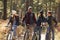 Group of friends on bikes in a forest looking at each other