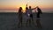 Group of friends celebrating with sparklers at the beach at sunrise