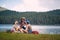 A group of friends is chatting beside the lake during hiking the hills. Trip, nature, hiking