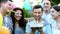 Group of friends congratulate happy man with his birthday, light and blowing out candles 21 on the cake, adulthood