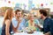 Group Of Friends Eating Meal On Rooftop Terrace