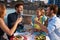 Group Of Friends Eating Meal On Rooftop Terrace