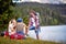 A group of friends enjoying beside the lake during hiking the hills. Trip, nature, hiking