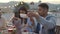 Group of friends enjoying summer barbecue at home terrace in the evening