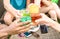 Group of friends hands drinking summer cocktails at beach bar