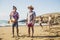 Group of friends have fun together at the beach - men standing and girls behind running to them to play - summer vacation beach