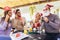 Group of friends having fun in cafe holding artificial mustache and lips stick