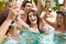 Group Of Friends Having Party In Pool Drinking Champagne