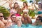 Group Of Friends Having Party In Pool Drinking Champagne