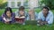 Group of friends lying on lawn on campus and preparing for test, student\'s life