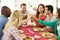 Group Of Friends Making Toast Around Table At Dinner Party