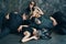 Group of friends in masquerade carnival mask sitting on floor relax after party