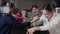 A group of friends are playing arm wrestling. Boy and girl wrestle on the table