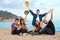 Group of friends raising hands on beach.