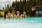 Group of friends relaxing in pool and drinking beer during vacation in mountains