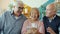 Group of friends retired people talking looking at smartphone screen at home