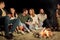 Group of friends sitting at camp fire on beach