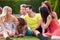 Group Of Friends Sitting On Grass Together