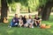 Group of friends sitting in park on grass and looking at camera