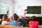 Group Of Friends Sitting On Sofa Watching Soccer Together