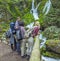 Group of friends standing in front of a waterfall and admiring the beautiful view of falling water