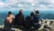 A group of friends, tourists resting on top of the mountain