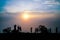 Group of friends or tourists stands silhoutte at mountains