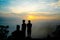 Group of friends or tourists stands silhoutte at mountains