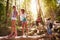 Group Of Friends On Walk Balancing On Tree Trunk In Forest