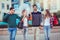 Group Of Friends Walking Along Street With Shopping Bags