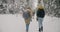 Group of friends walking together in winter forest talking enjoying natural landscape