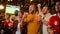 Group of Friends Watching a Live Soccer Match on TV in a Sports Bar. Three Men Cheering and Shouting