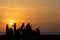 Group Gang of Teenagers Young Adults watch a beach side sun set