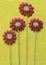 Group of gingerbread flowers on yellow felt background.